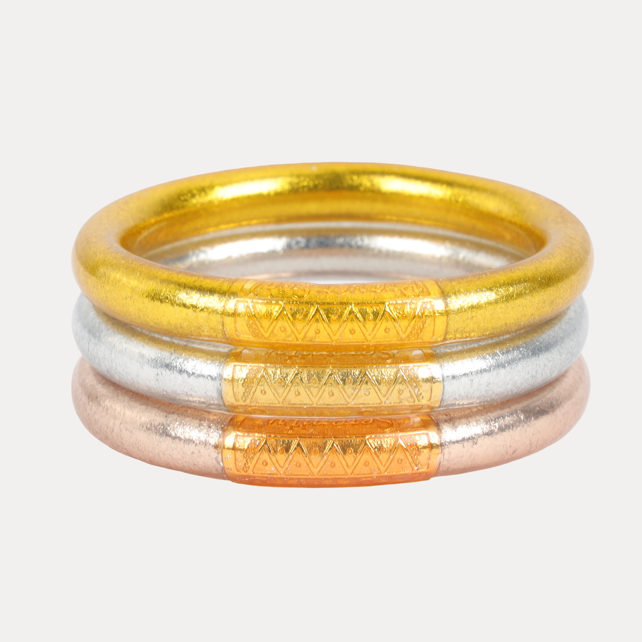 a stack of gold silver and bronze rings