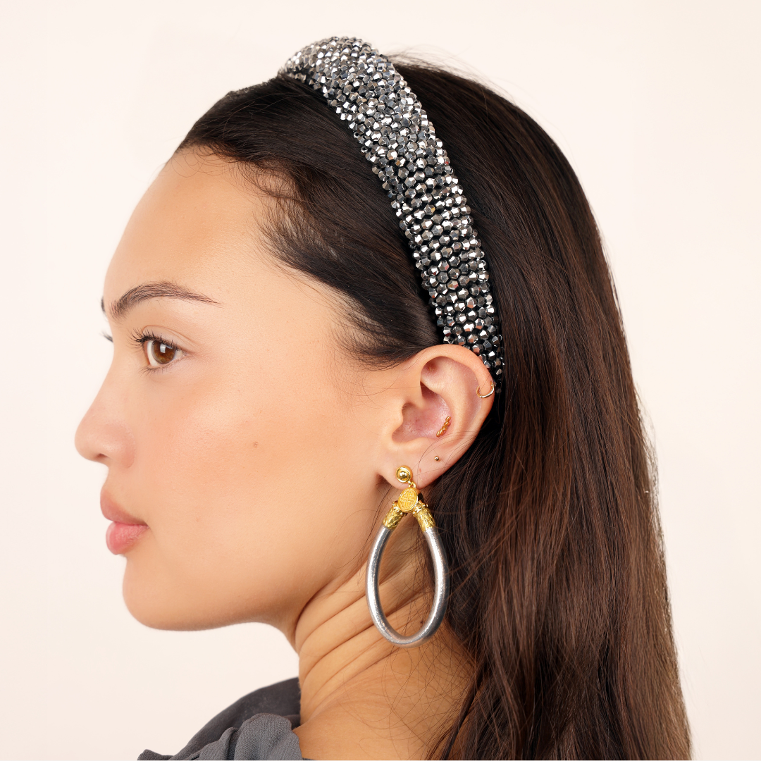 a woman with a headband and earrings