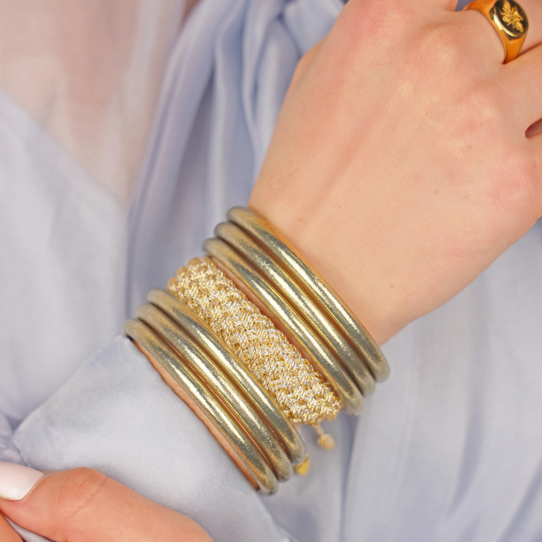 a hand with gold bracelets