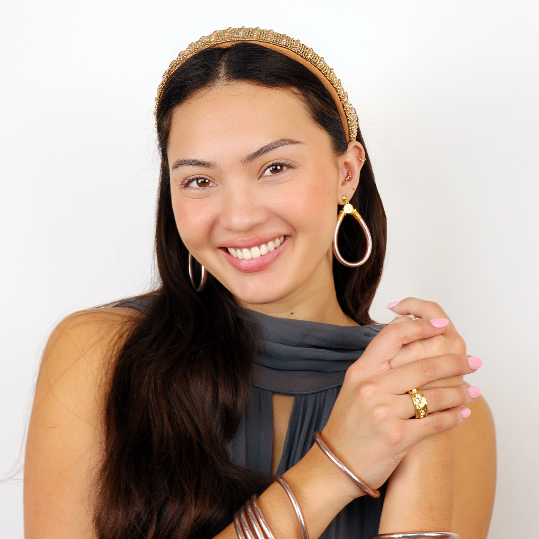 a woman smiling with gold jewelry