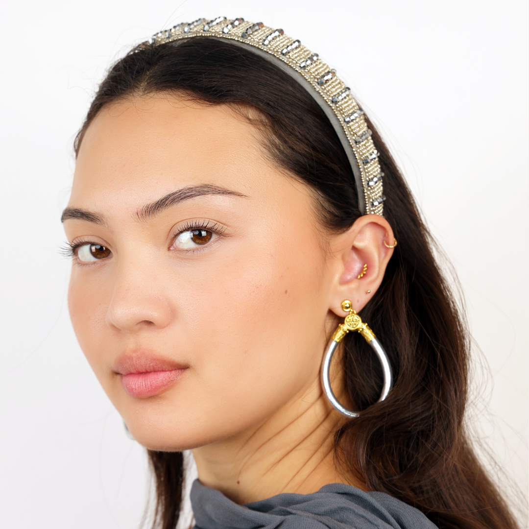 a woman with a headband and earrings