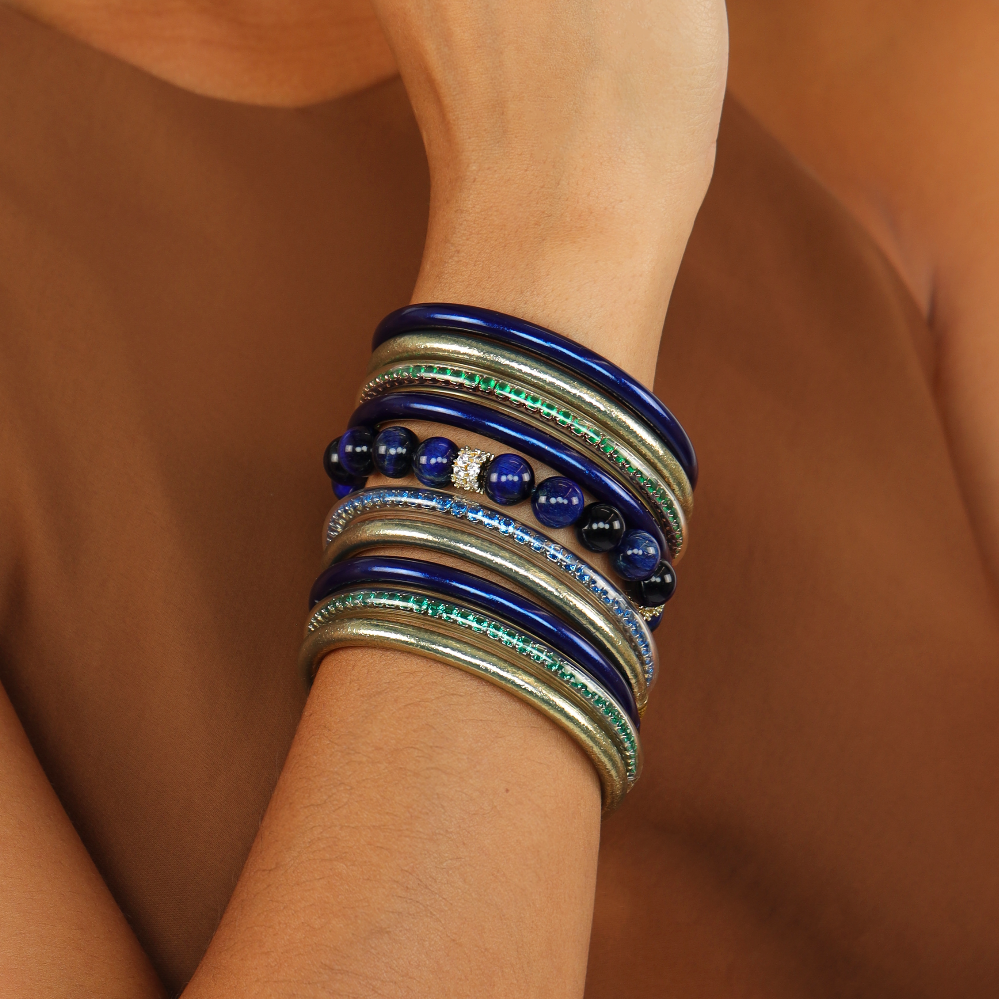 The American Classic Bundle featuring elegant Bangle Bracelets in layered blue and gold tones on a wrist.