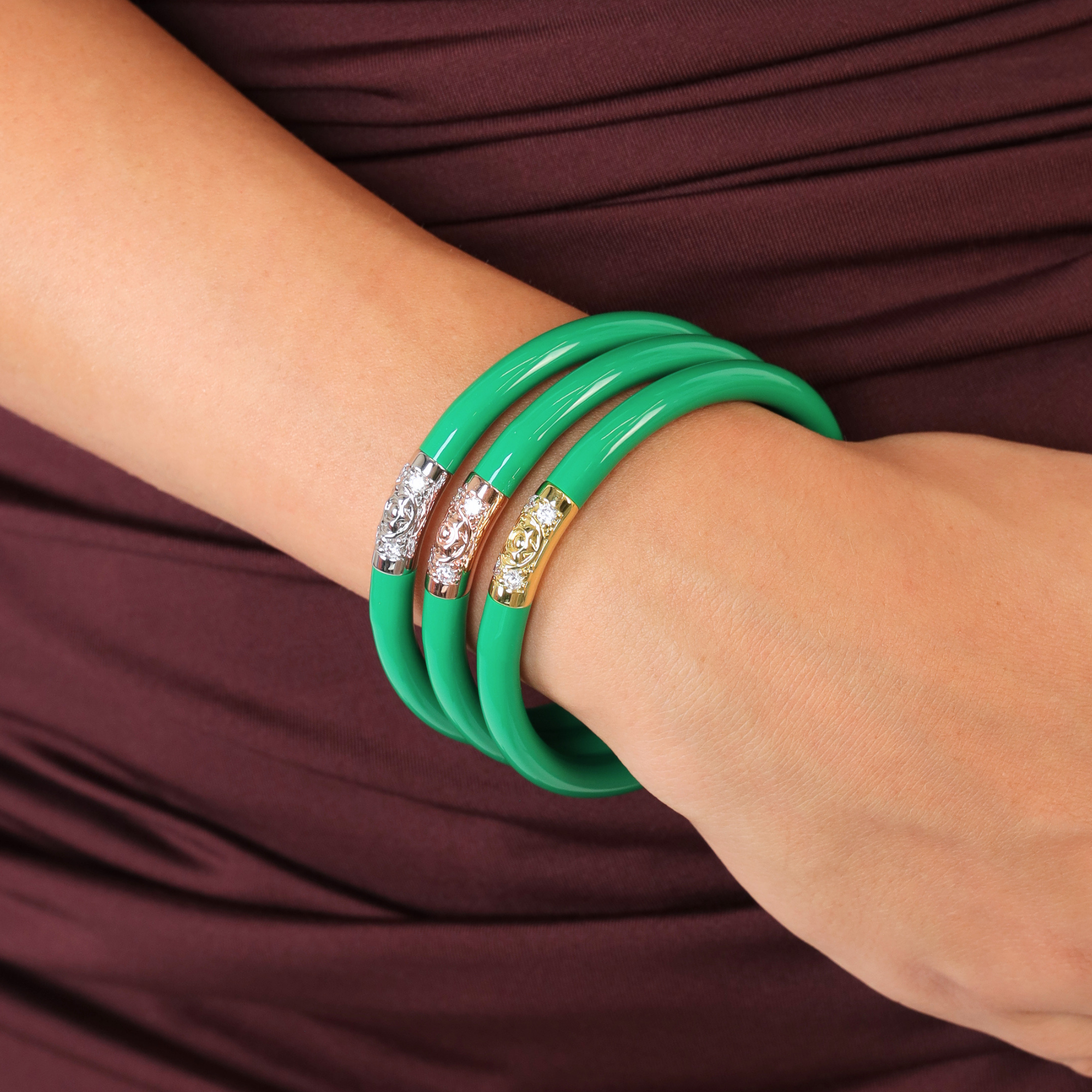 The Midnight Kelly Bundle featuring vibrant green bangle bracelets elegantly worn on a wrist.
