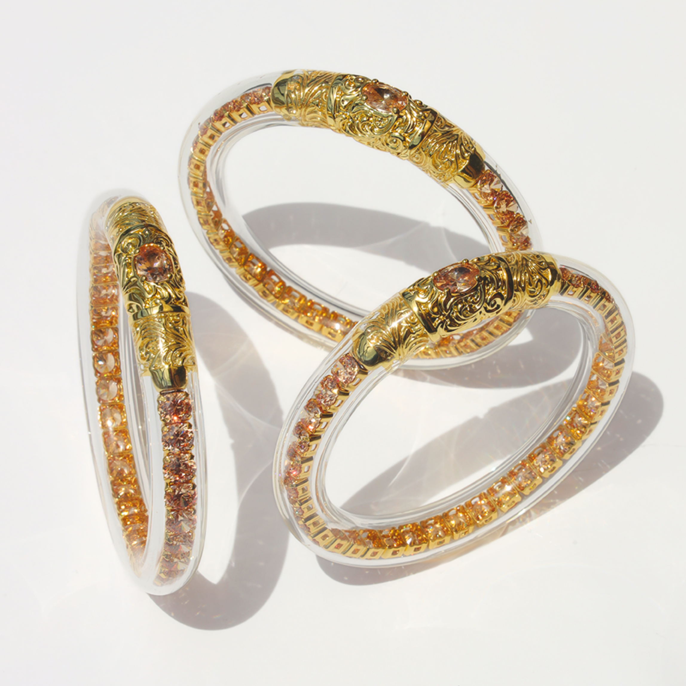 a group of bracelets with gold and orange stones