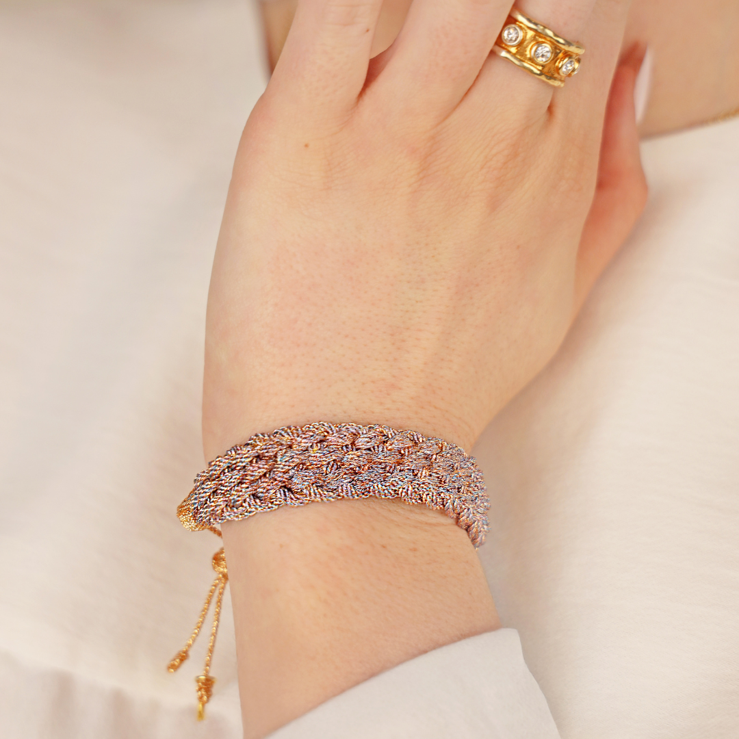 a hand with gold jewelry on it