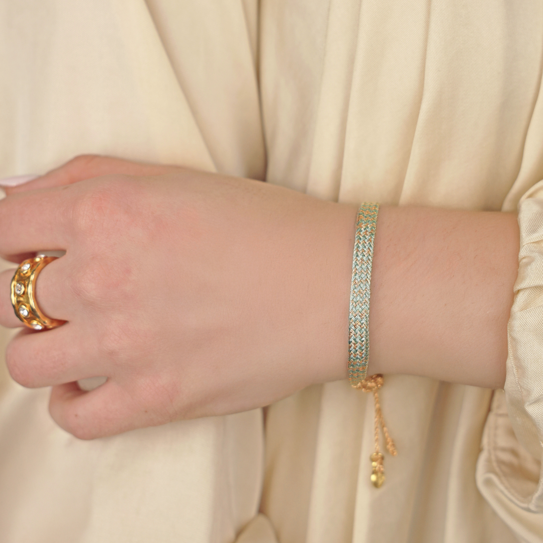 a hand with a gold bracelet
