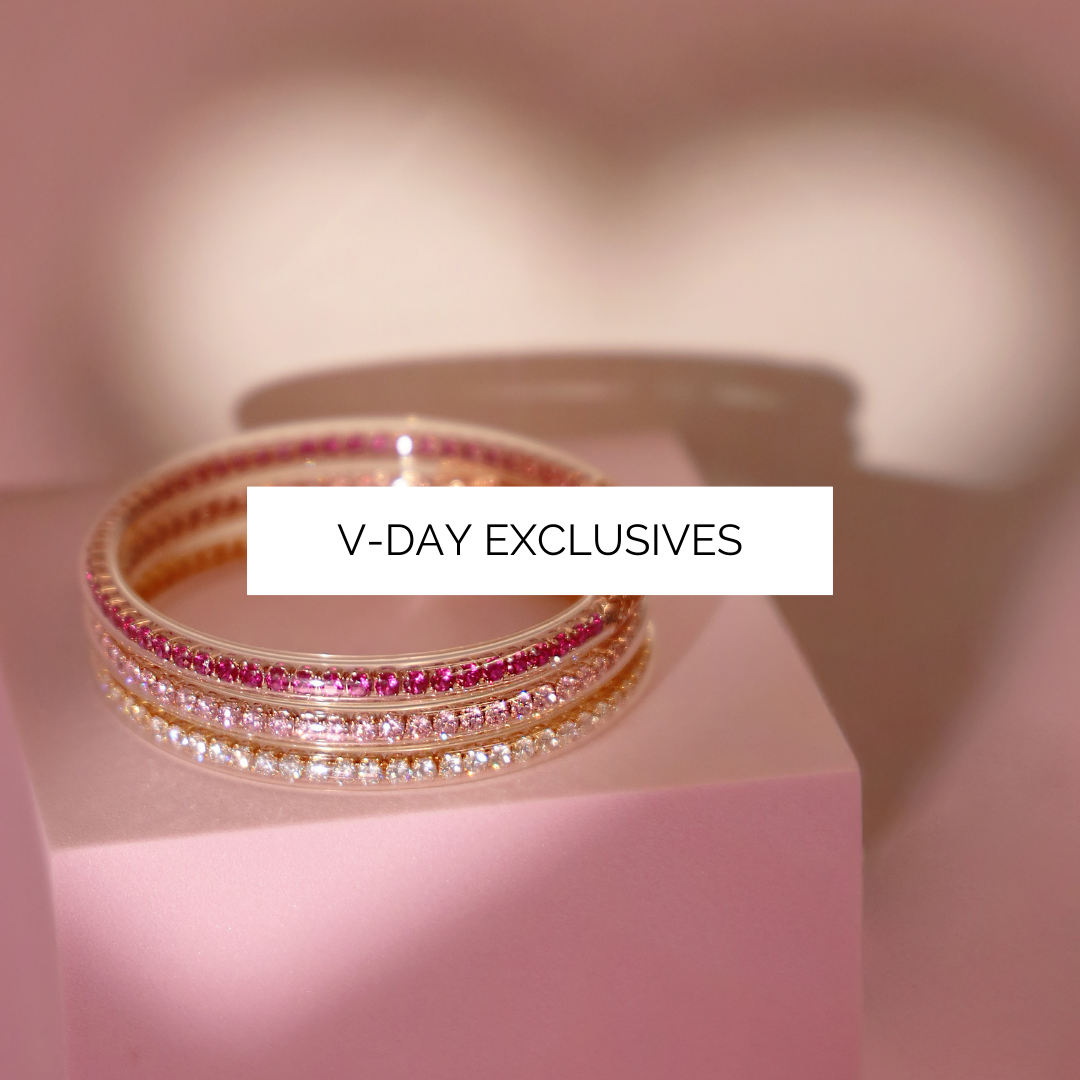 Stack of bracelets on a pink platform with 'V-Day Exclusives' text