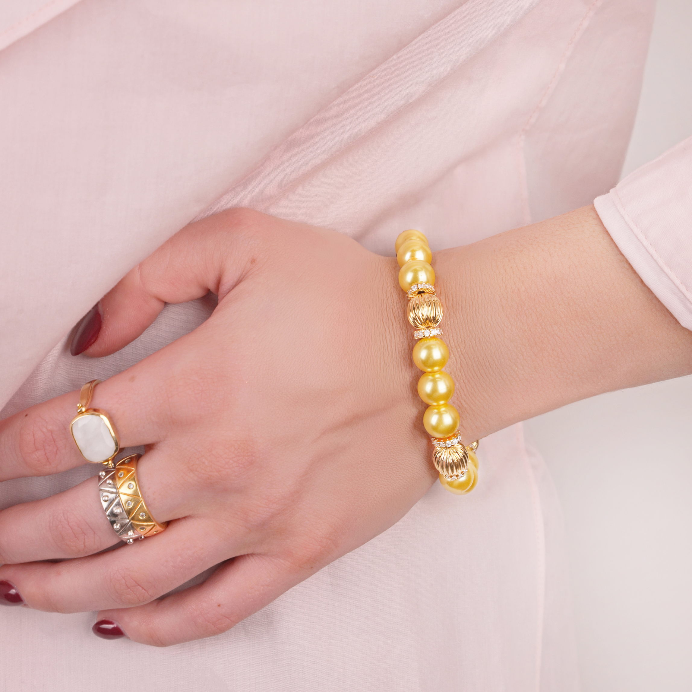 a hand with a bracelet and ring