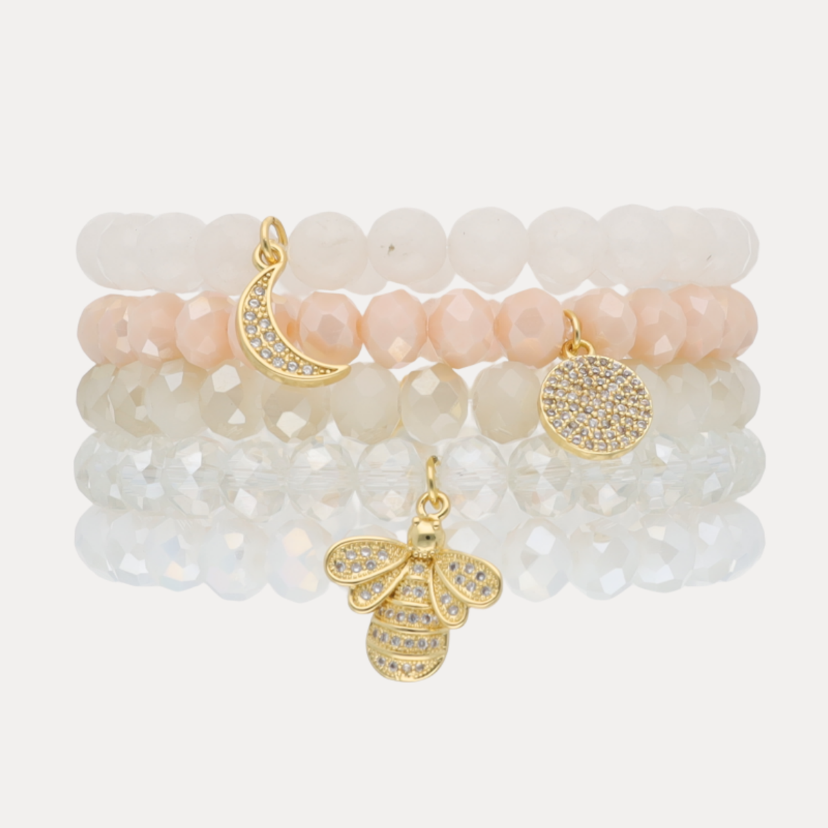 a stack of bracelets with a bee charm