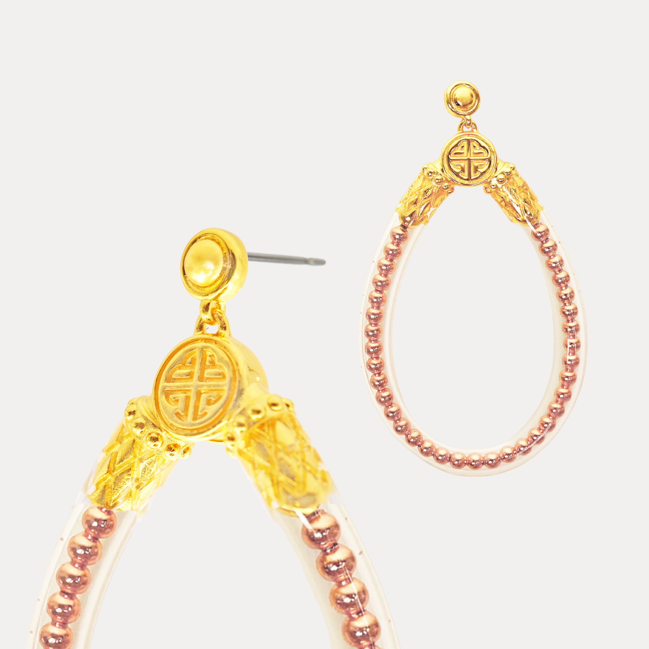 a pair of gold and pink earrings