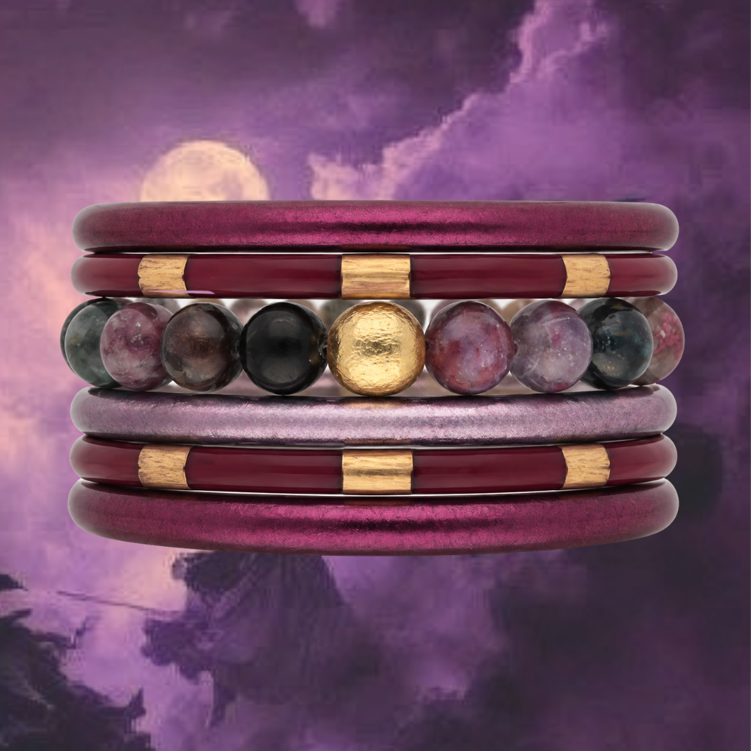 a stack of purple and gold bracelets